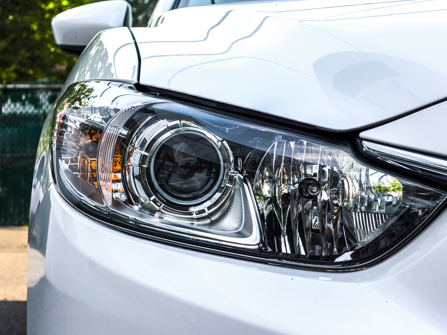 The headlight and fender of a white car.